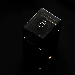 Czarny, szklany flakonik perfum z logo "CD". Czy perfumy mają datę ważności? Ten flakonik wygląda na wieczny.