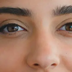 Zbliżenie na oczy kobiety z makijażem typu foxy eyes. Wyraziste brwi i subtelna kreska podkreślają spojrzenie.