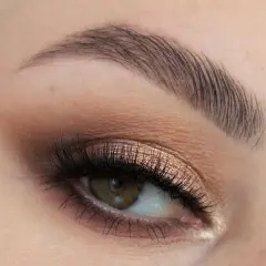 Oko z perfekcyjnym makijażem ślubnym smoky eyes, podkreślone długimi rzęsami i subtelnym cieniem w odcieniach brązu i złota.