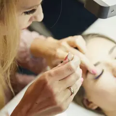 Profesjonalne szkolenie laminacja brwi i rzęs. Stylistka pracuje nad brwiami klientki, tworząc idealny kształt.