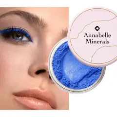 Oko podkreślone intensywnym, niebieskim eyelinerem. Obok słoiczek z sypkim, niebieskim cieniem Annabelle Minerals.