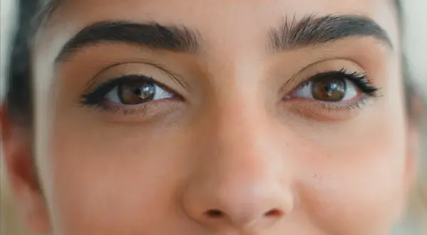 Zbliżenie na oczy kobiety z makijażem typu foxy eyes. Wyraziste brwi i subtelna kreska podkreślają spojrzenie.