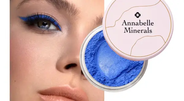 Oko podkreślone intensywnym, niebieskim eyelinerem. Obok słoiczek z sypkim, niebieskim cieniem Annabelle Minerals.