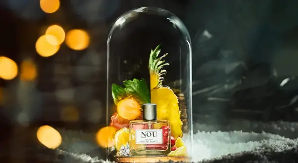 Perfumy NOU "Secret Blanc" w szklanej kopule, otoczone owocami i zielenią. Idealne miejsce, gdzie trzymać perfumy, by zachować ich świeżość.