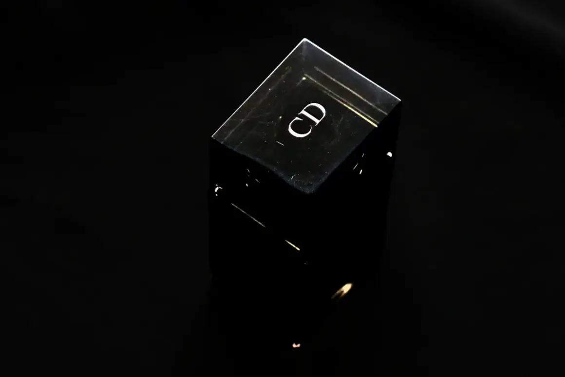Czarny, szklany flakonik perfum z logo "CD". Czy perfumy mają datę ważności? Ten flakonik wygląda na wieczny.