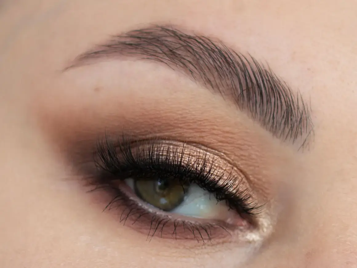 Oko z perfekcyjnym makijażem ślubnym smoky eyes, podkreślone długimi rzęsami i subtelnym cieniem w odcieniach brązu i złota.