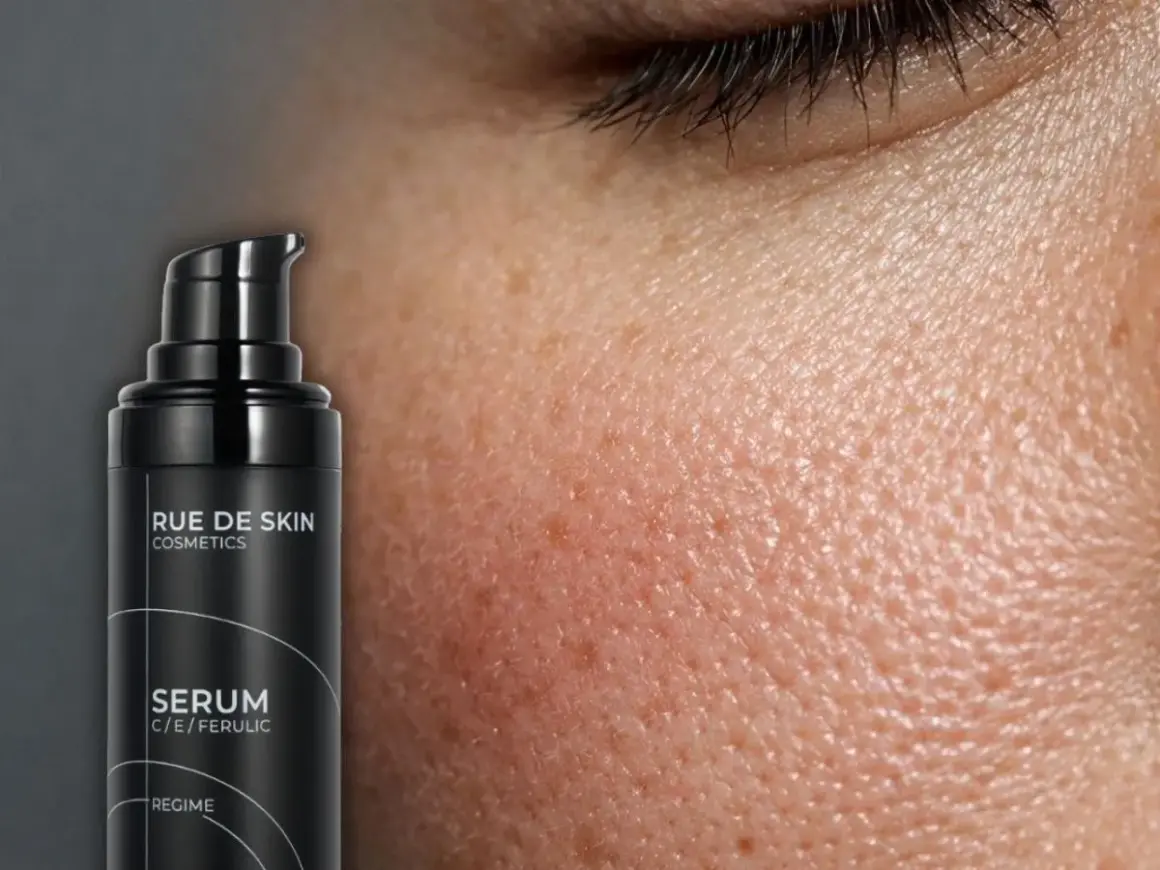 Serum z witaminą C rano czy wieczorem? Czarna buteleczka Rue de Skin z serum C/E/Ferulic obok skóry z widocznymi porami.