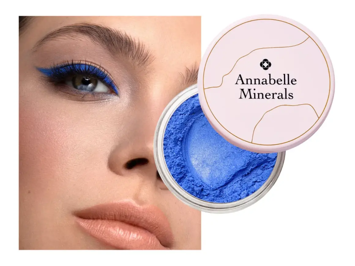 Oko podkreślone intensywnym, niebieskim eyelinerem. Obok słoiczek z sypkim, niebieskim cieniem Annabelle Minerals.