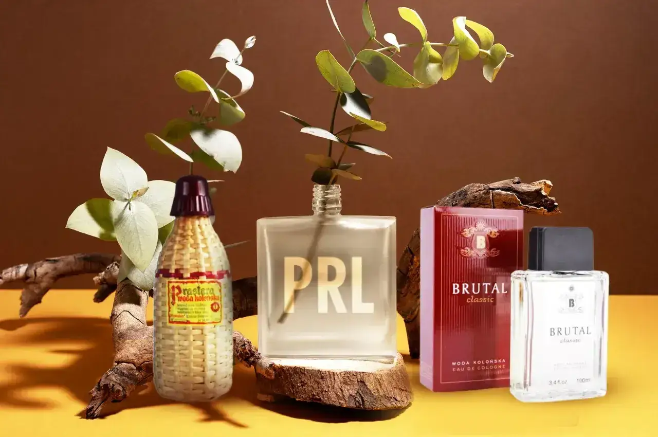 Kultowe polskie perfumy z lat 70. i 80. - Prastara, Brutal Classic i tajemniczy flakon z napisem PRL, otoczone gałązkami eukaliptusa i fragmentami drewna.