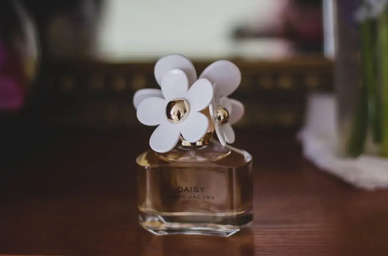 Flakonik perfum Daisy Marc Jacobs z białymi kwiatkami. Czy perfumy mają datę ważności? Ten zapach wciąż kusi.