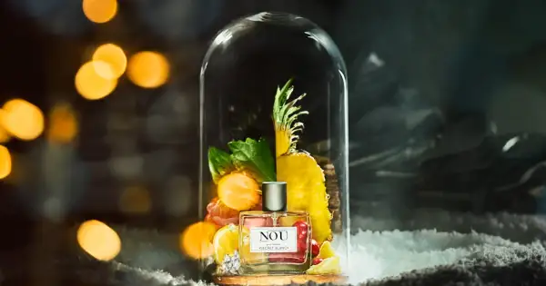 Perfumy NOU "Secret Blanc" w szklanej kopule, otoczone owocami i zielenią. Idealne miejsce, gdzie trzymać perfumy, by zachować ich świeżość.